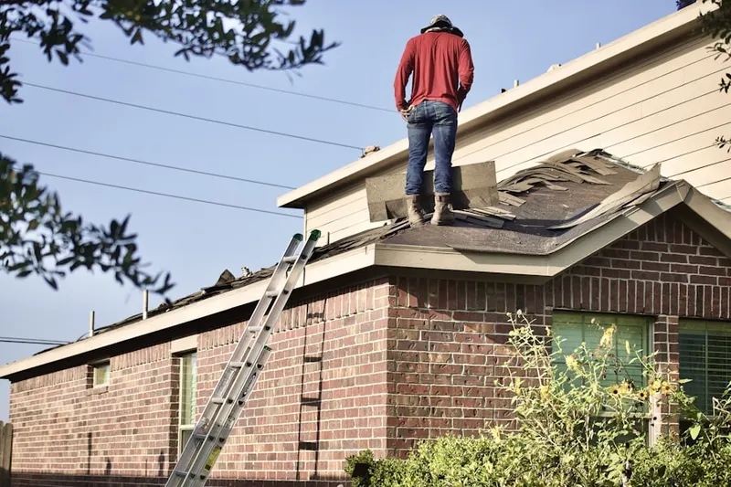 Professional roofer working on a residential roof in Camelot